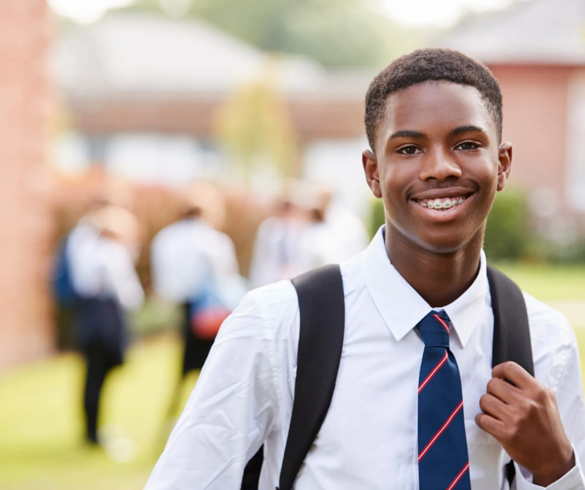 A smiling high school student with a backpack